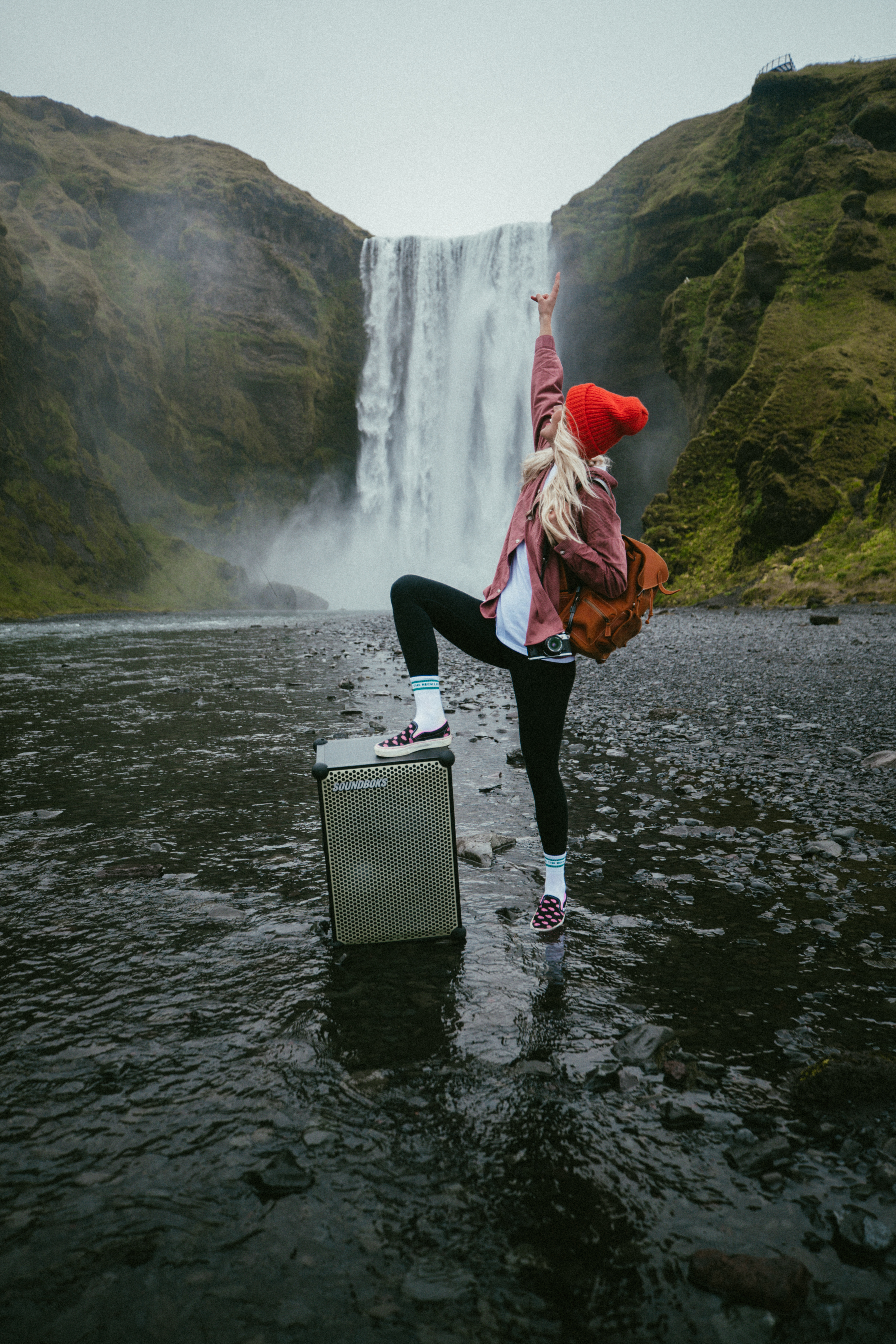 Social media influencer, Asa, in iceland with a SOUNDBOKS martian edition in front of a waterfall.