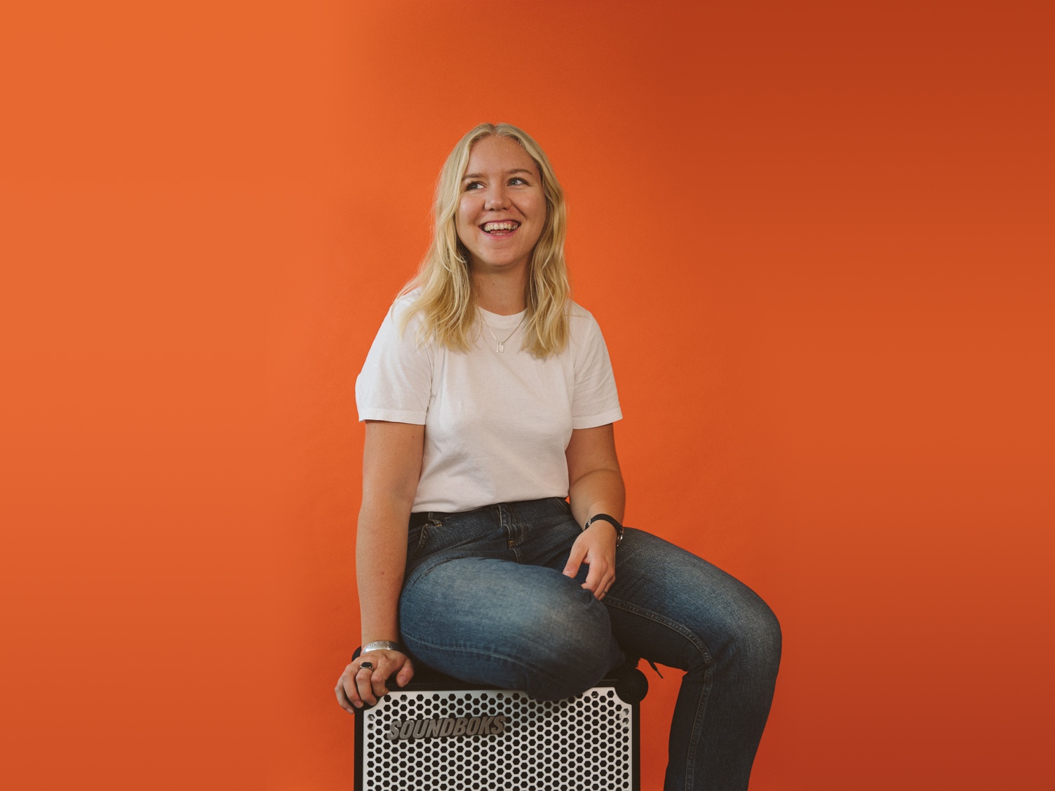 Gesche, blonde girl sitting on a white SOUNDBOKS