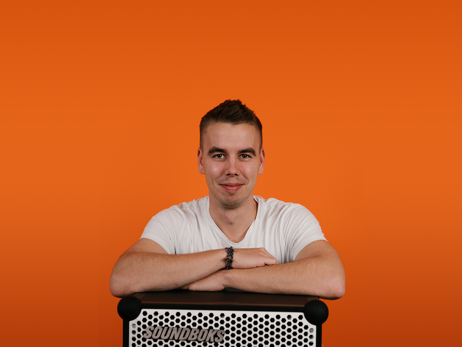 emil, a supply chain coordinator at soundboks leaning on top of a soundboks speaker