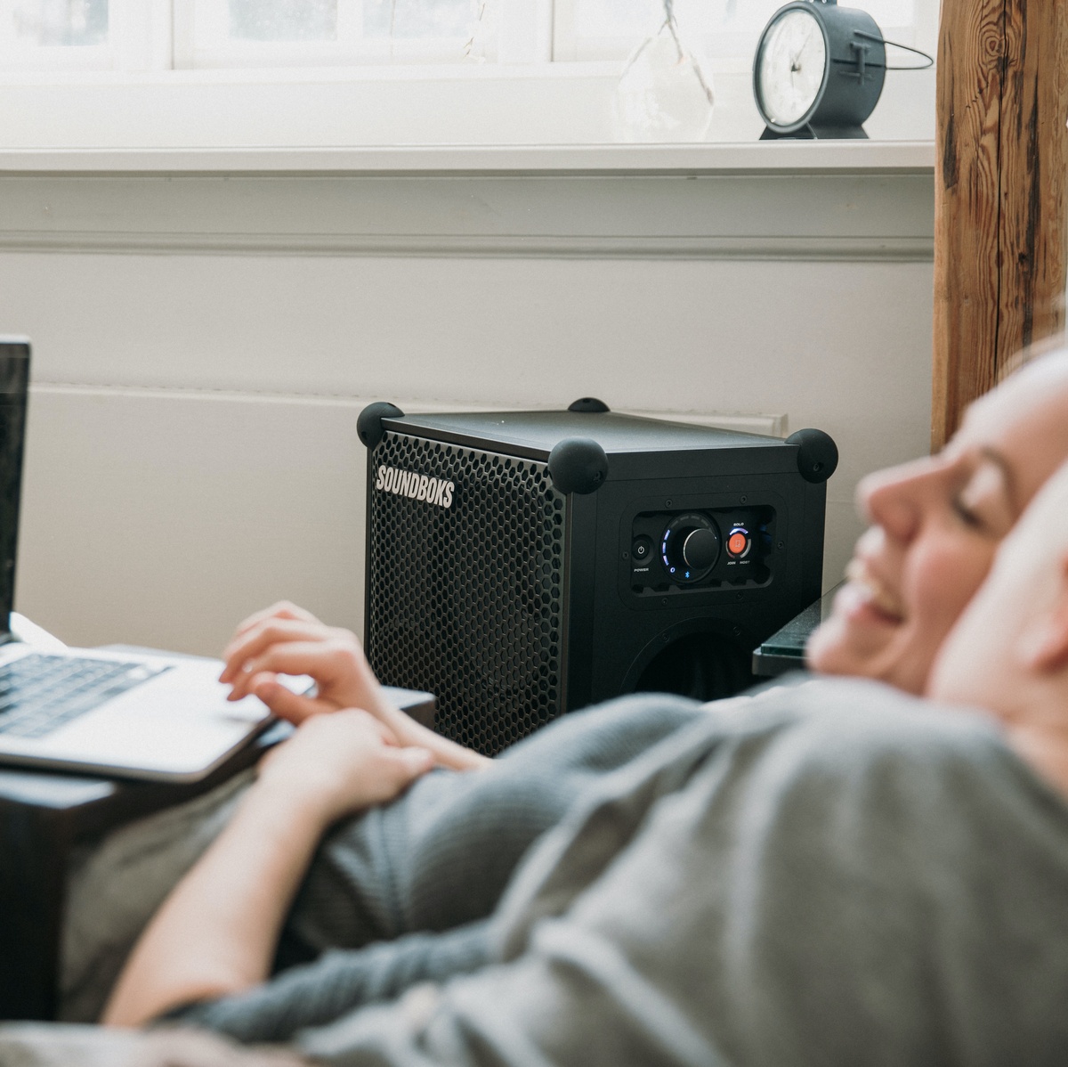 SOUNDBOKS inside of a house while 2 people watch TV