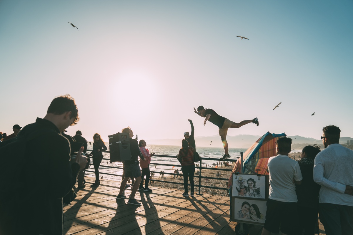 man standing on ledge dancing and giving a high five while listening to a soundboks