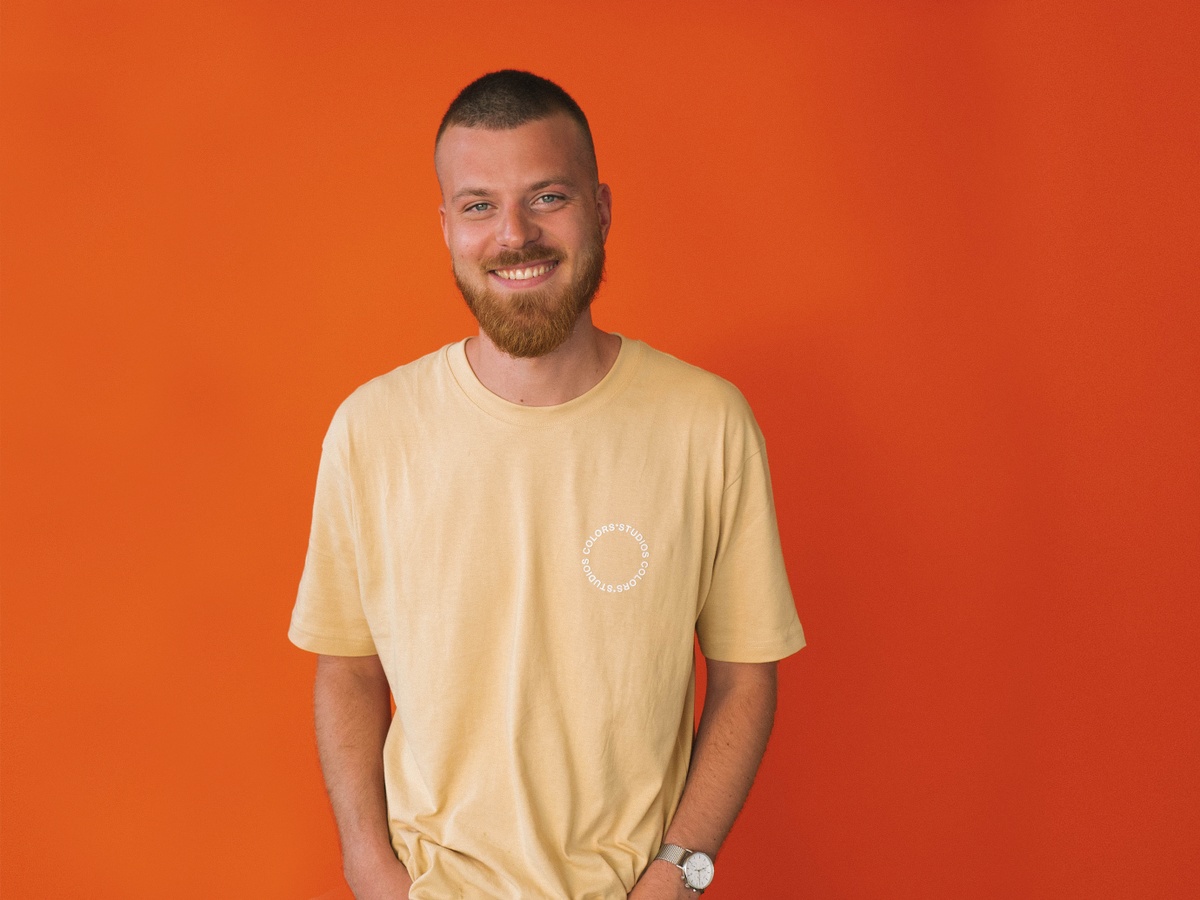 Fred, the creative director at SOUNDBOKS in front of an orange background
