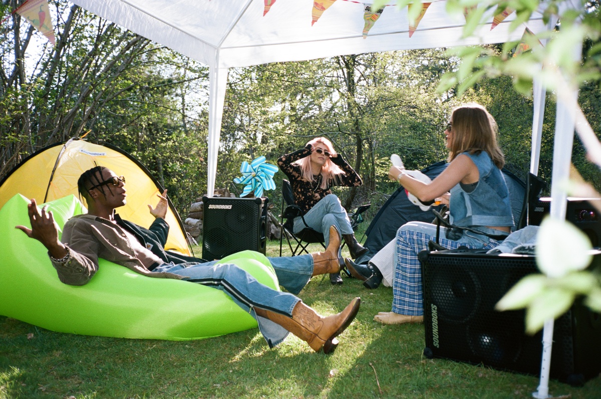 cool young people hanging out with their soundboks in a backyard