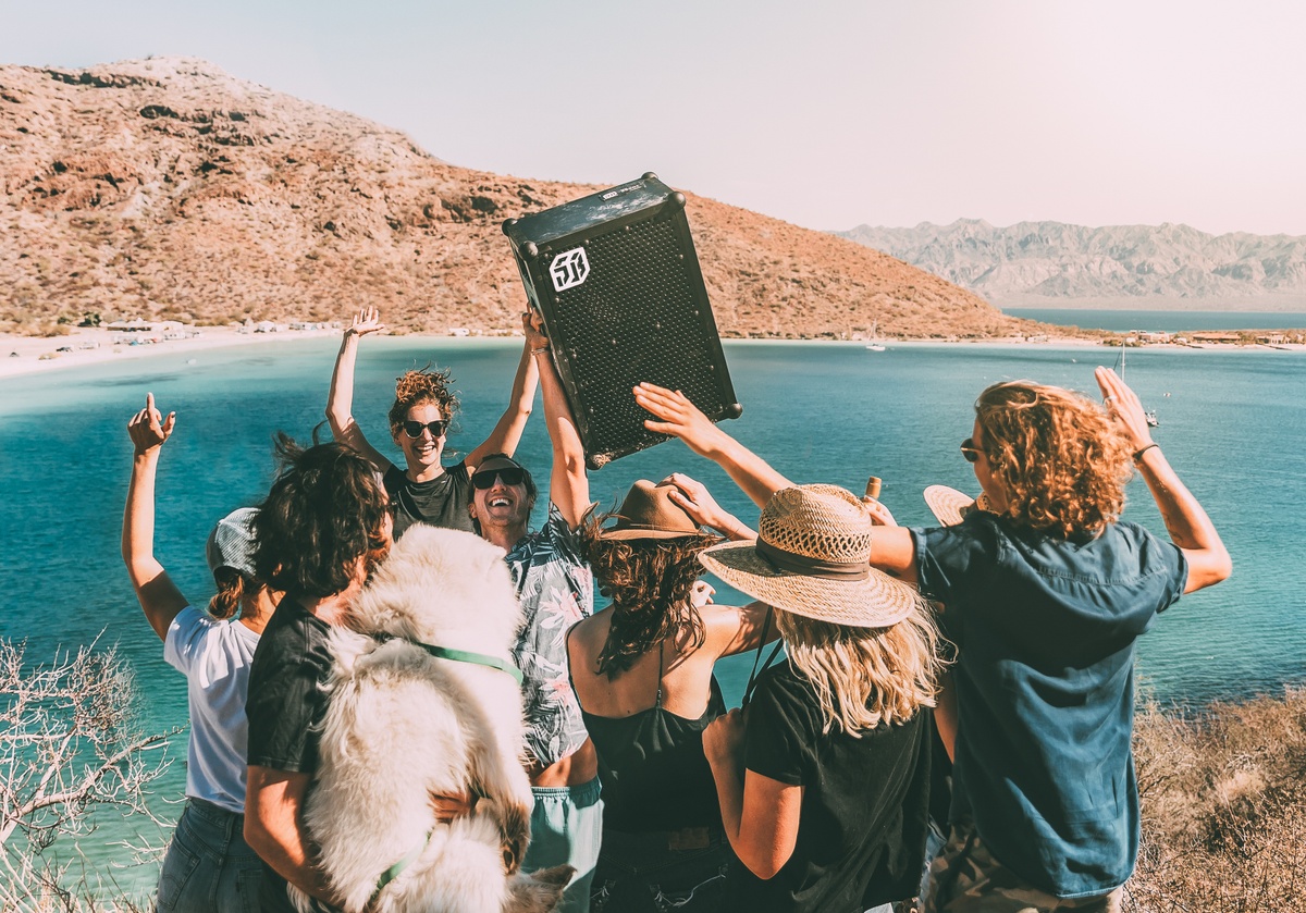 group of people partying by a lake with a SOUNDBOKS speaker