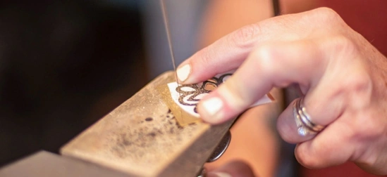 jeweler sawing out a floral design