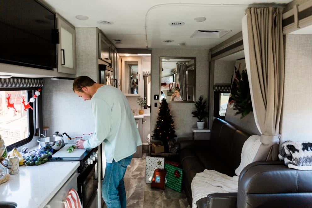 man cooking dinner in RV at Christmas