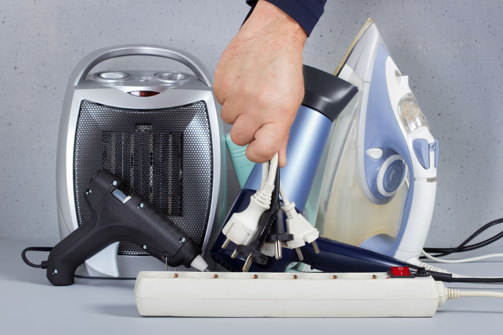 person unpluging appliances to reduce average electric bill in florida