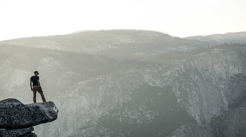 Man with camera on mountaintop