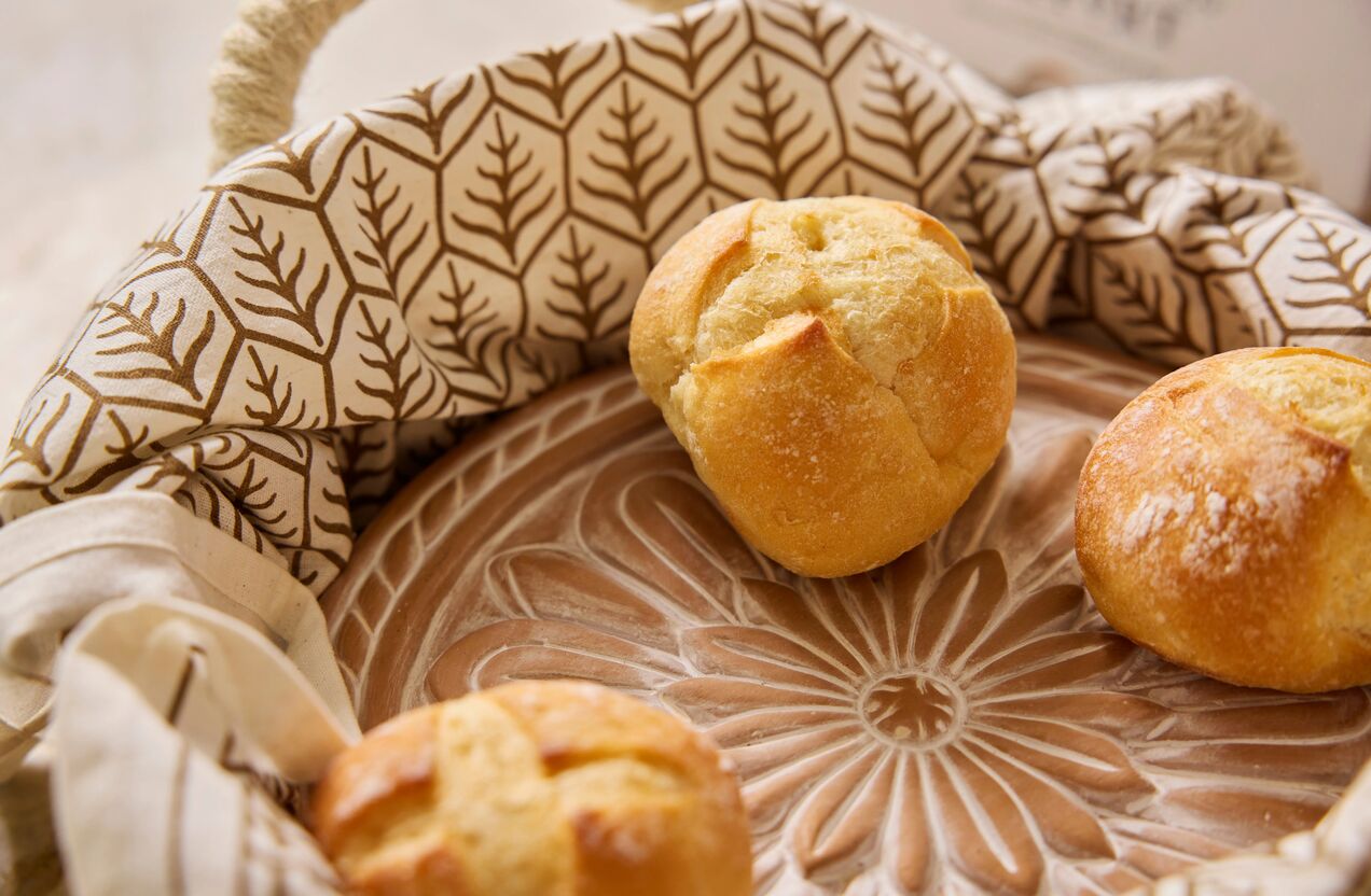 Bread basket product with a tea towel and delicious rolls inside