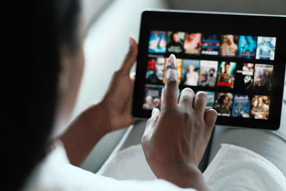 woman streaming tv or film on tablet
