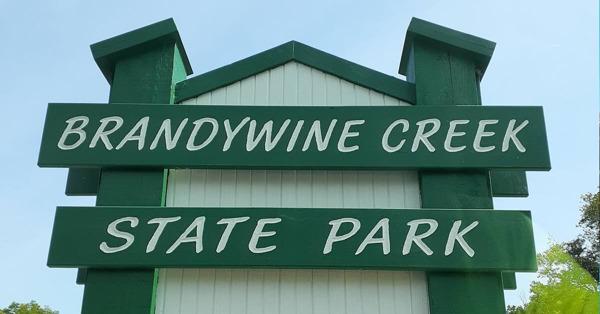 A green and white wooden welcome sign