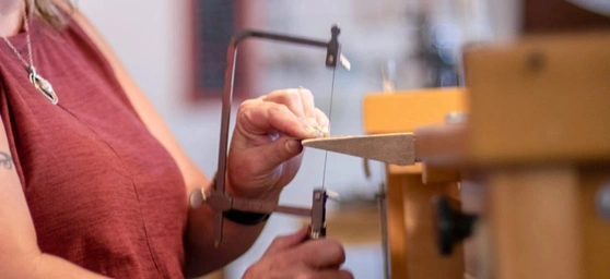 side view of a jeweler sawing