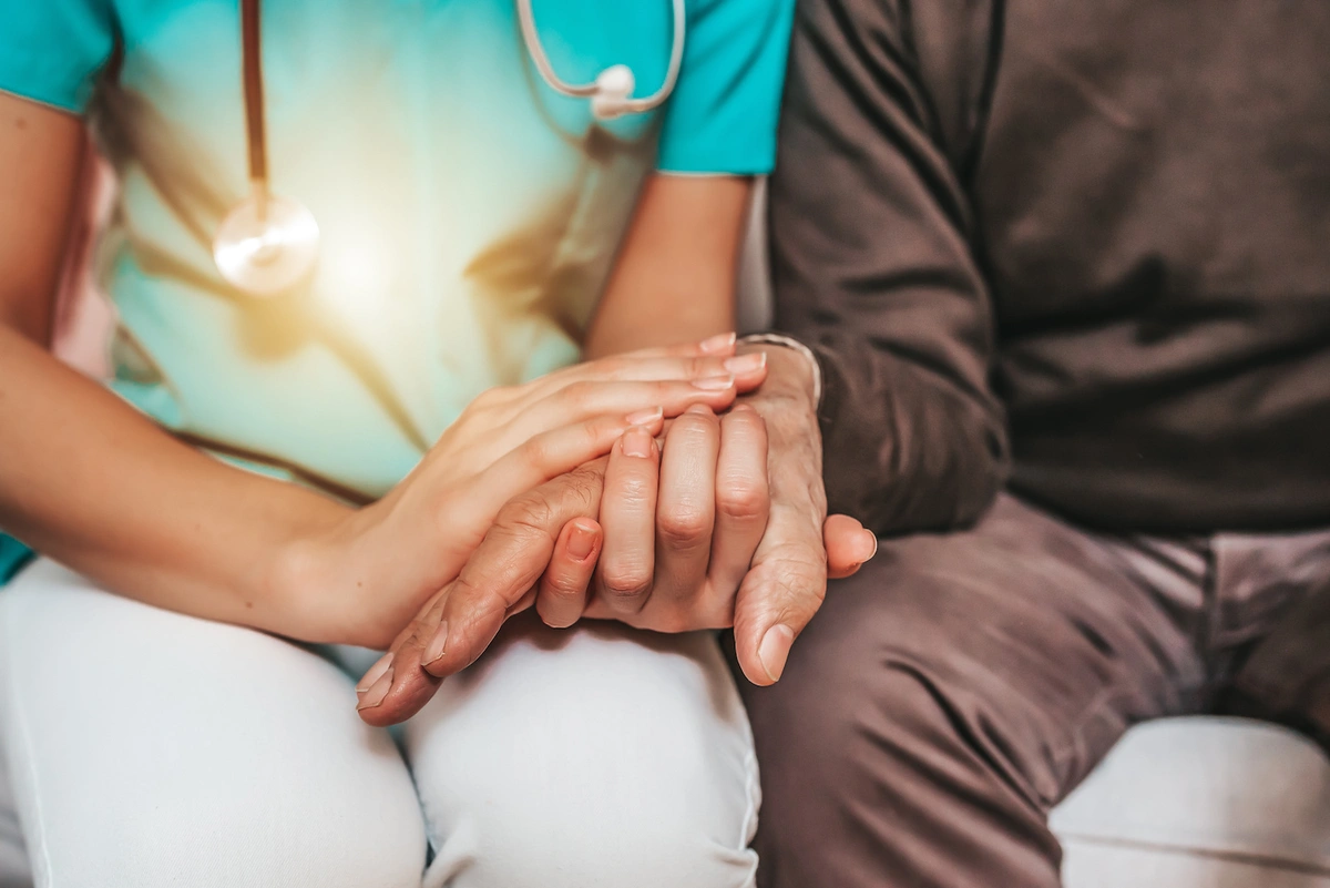 doctor and patient holding hands in a long-term care facility