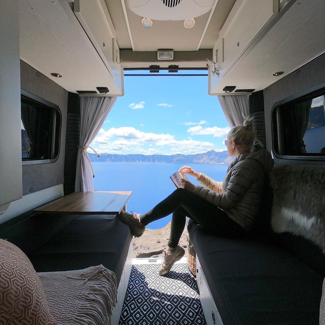 A person sitting on a couch looking out the window of a rv