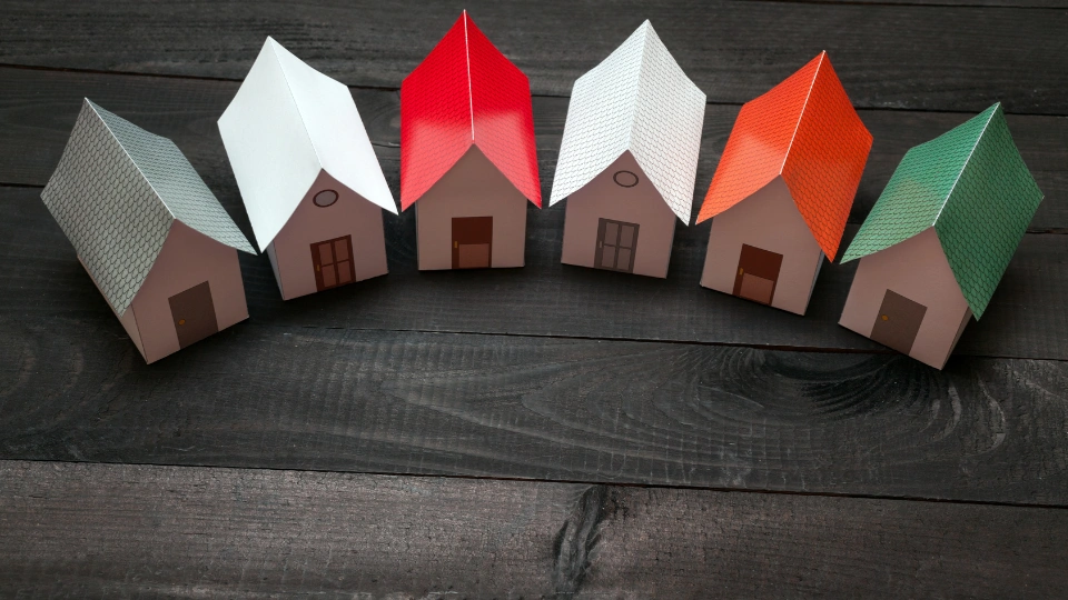 Papercraft Houses in a row on a dark wooden surface