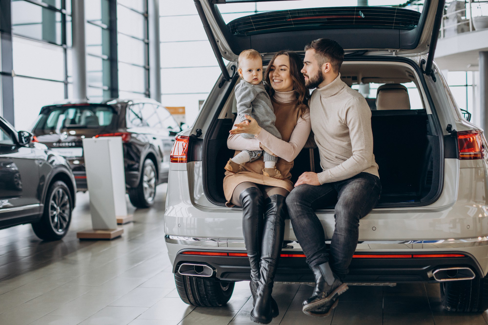family-with-toddler-girl-choosing-car...