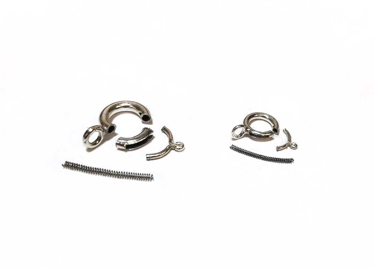 Interior components of a silver spring ring clasp in two sizes