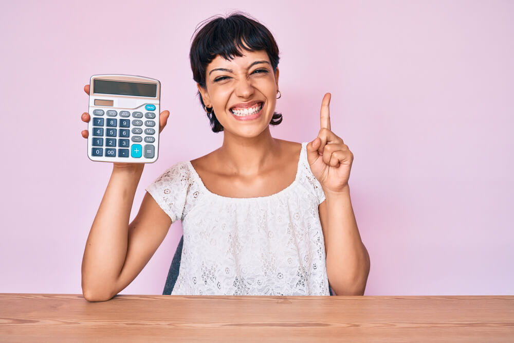 smiling woman holding calculator in air with one hand