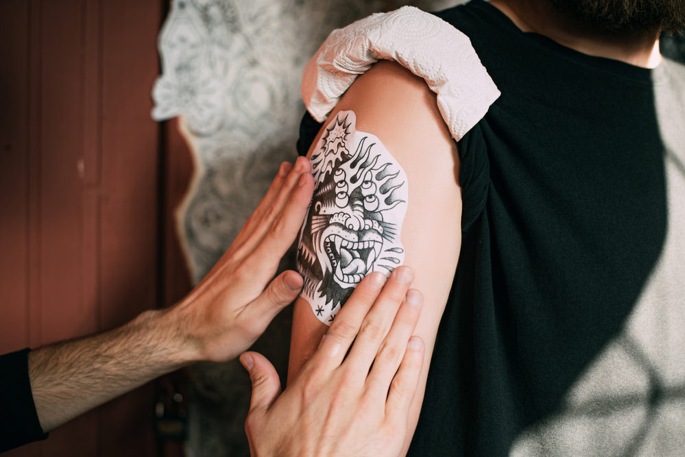 tattooist applying stencil