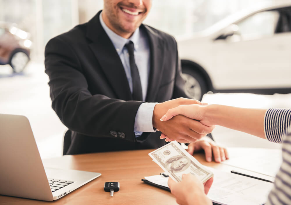 Representative shaking hands with customer for title loans
