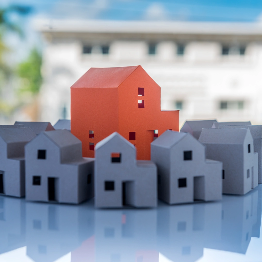 A bunch of little houses around a big red house.