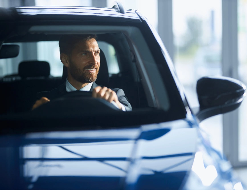 Happy investor in a car celebrating GM stock buyback news and float reduction—BuyBack Analytics tracks corporate share repurchases and capital behavior