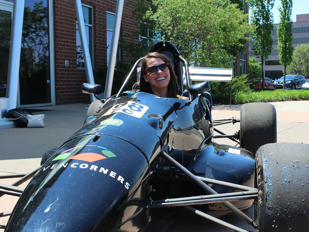 Team member buckled up for a ride in the Seven Corners Indy race car.