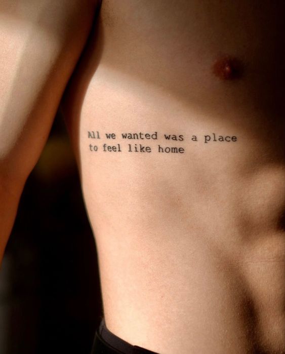 quote tattoo on man's ribs