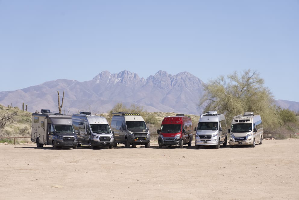 caravan of rvs and vans in desert