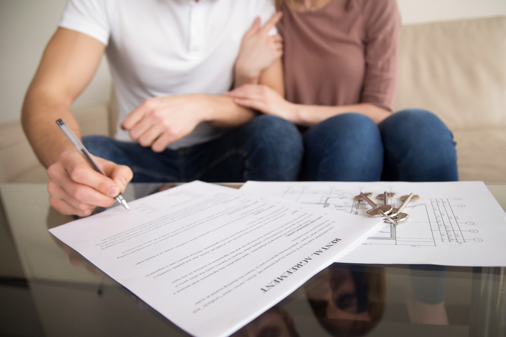 Couple signing tenancy agreement
