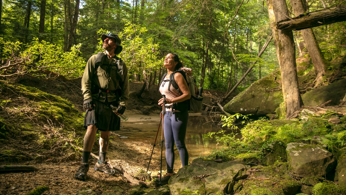 Two people hiking in the Alabama wilderness admiring the landscape