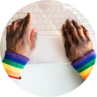 Man typing with rainbow sleeves