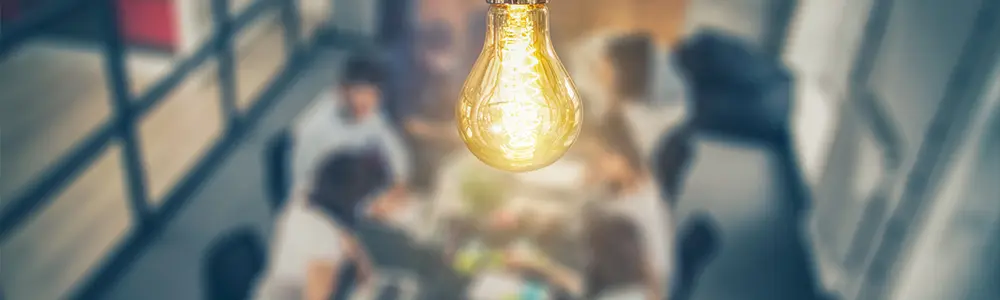 people in conference room with lightbulb in focus