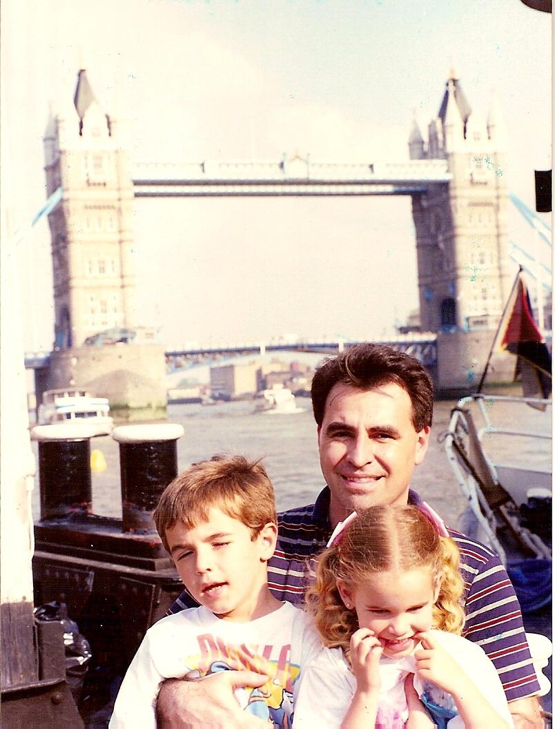 man holding kids in front of london bridge
