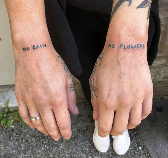 quote tattoo on man's wrists