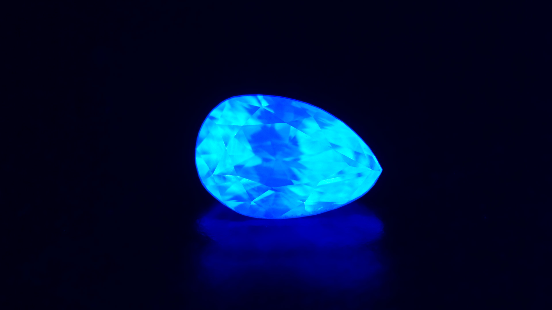 A pear shaped diamond with strong fluorescence under a black light