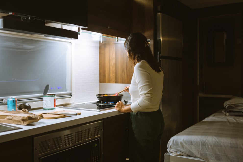 woman cooking in the winnebago navion