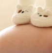 sapatinhos de bebê em cima da barriga de uma gestante, cuidados gestação, obstetra