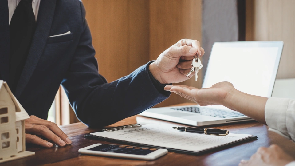 Property manager holding keys and handing to a customer