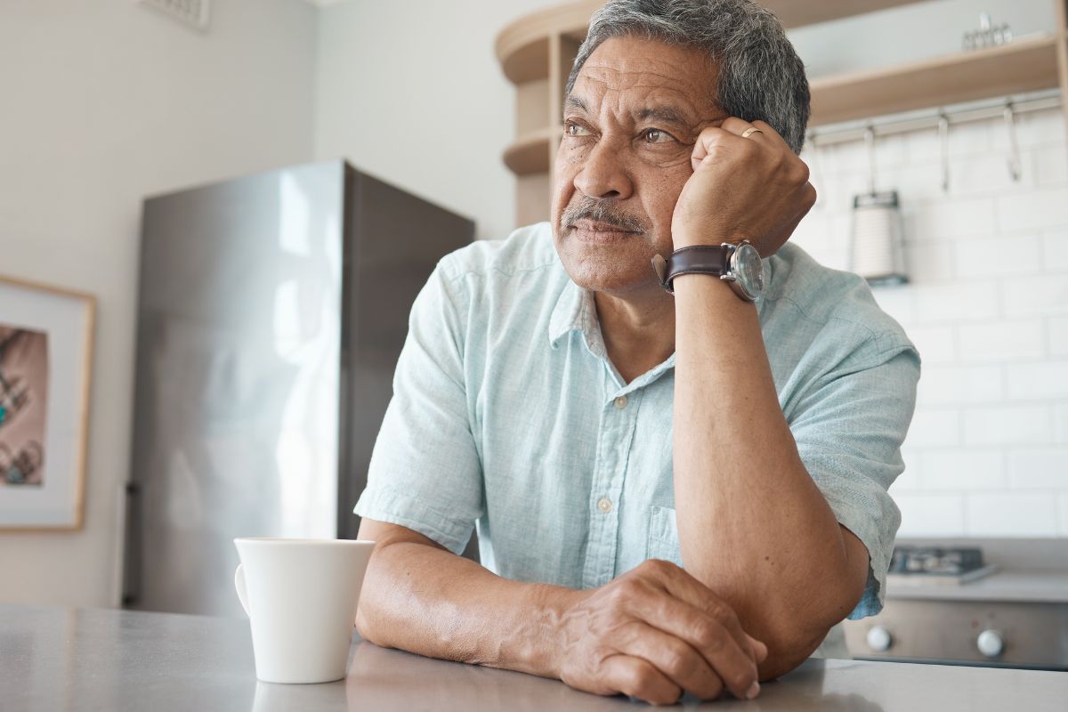 man sitting in kitchen wondering if he should buy a medicare advantage plan