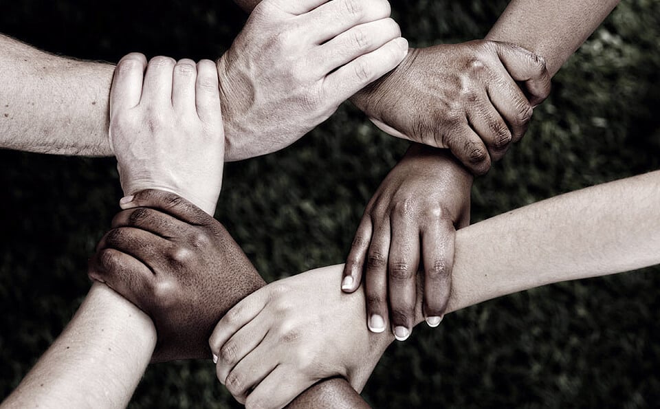 Hands of people from different races form a ring