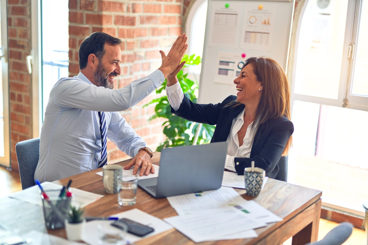 Two people high fiving.