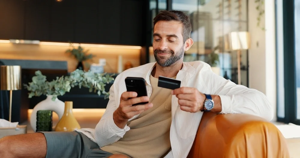 Man holding a credit card and his mobile phone