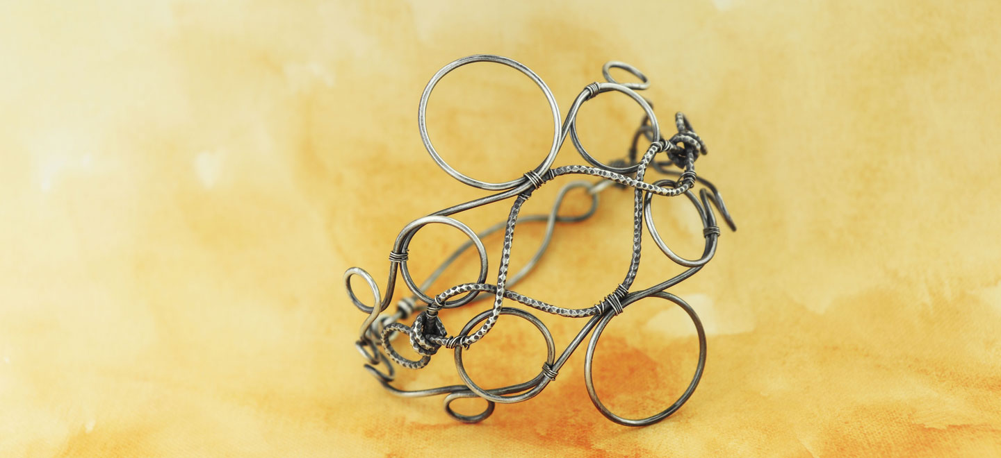 Learn how to use a wire jig tool to make stunning wirework bracelet designs out of bulk jewelry wire. Brenda Schweder offers tips for success.