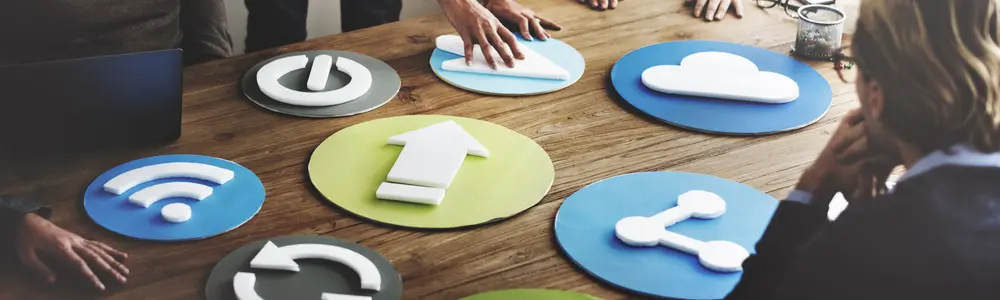 people placing colorful illustrations on conference table