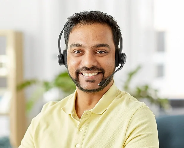 IT helpdesk representative smiling at desk