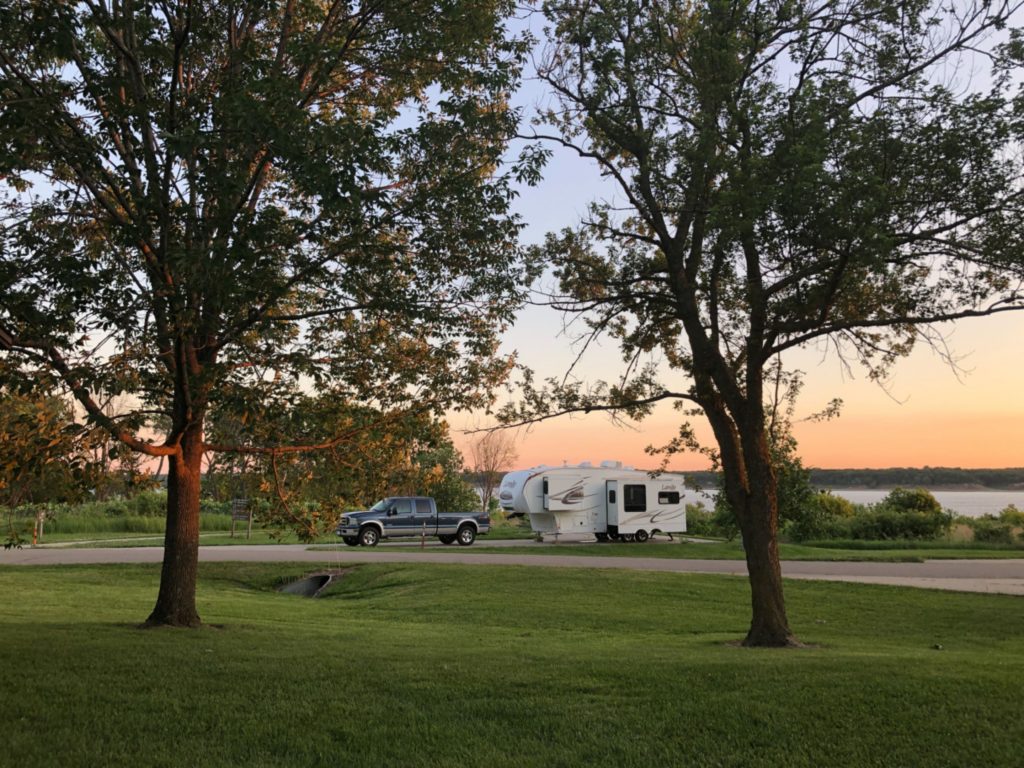 RV partked at camground at the lake during sunset