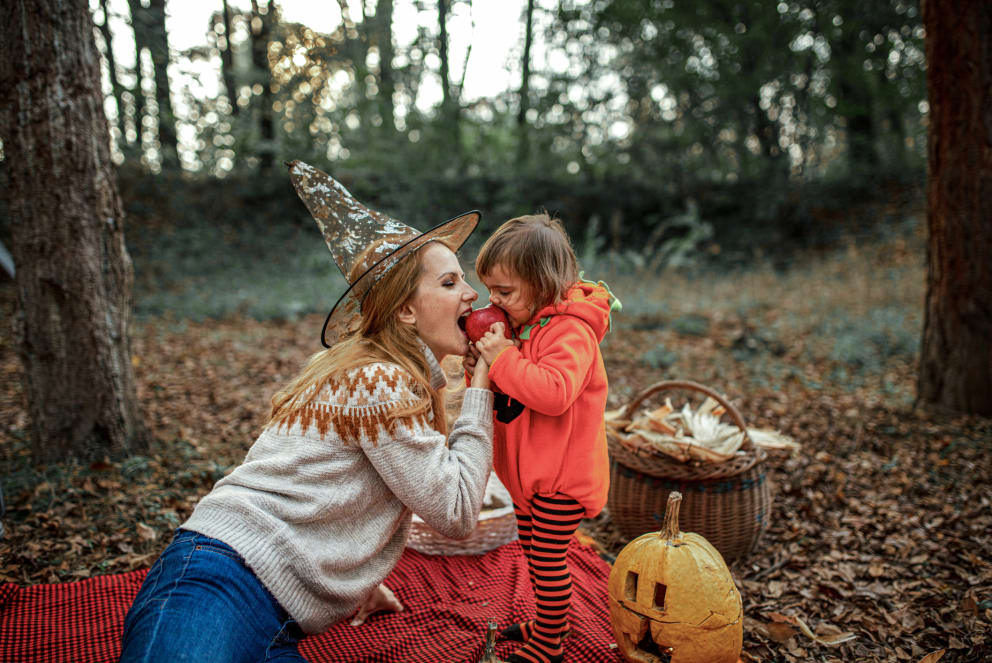 mom and daughter eat an apple during halloween