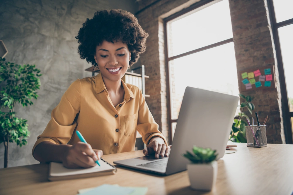 woman on laptop with notepad