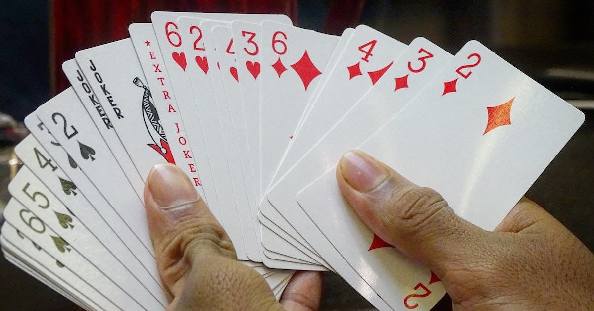 Hands fanning out a deck of playing cards